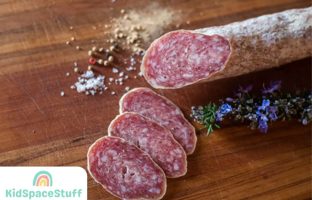 Salami slices near spices and rosemary