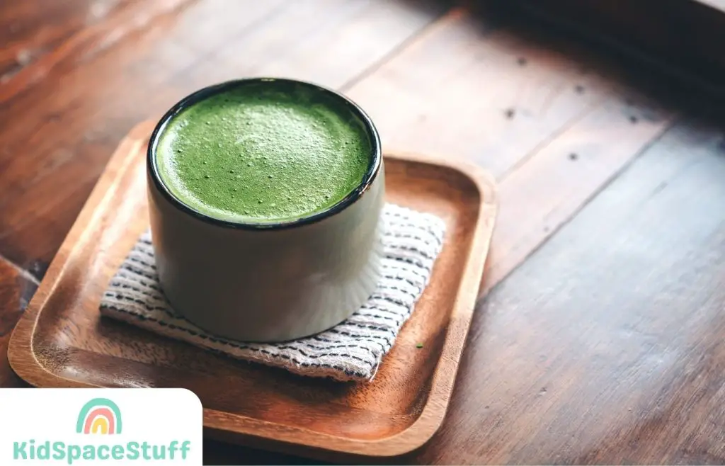 A cup of hot matcha latte on wooden floor