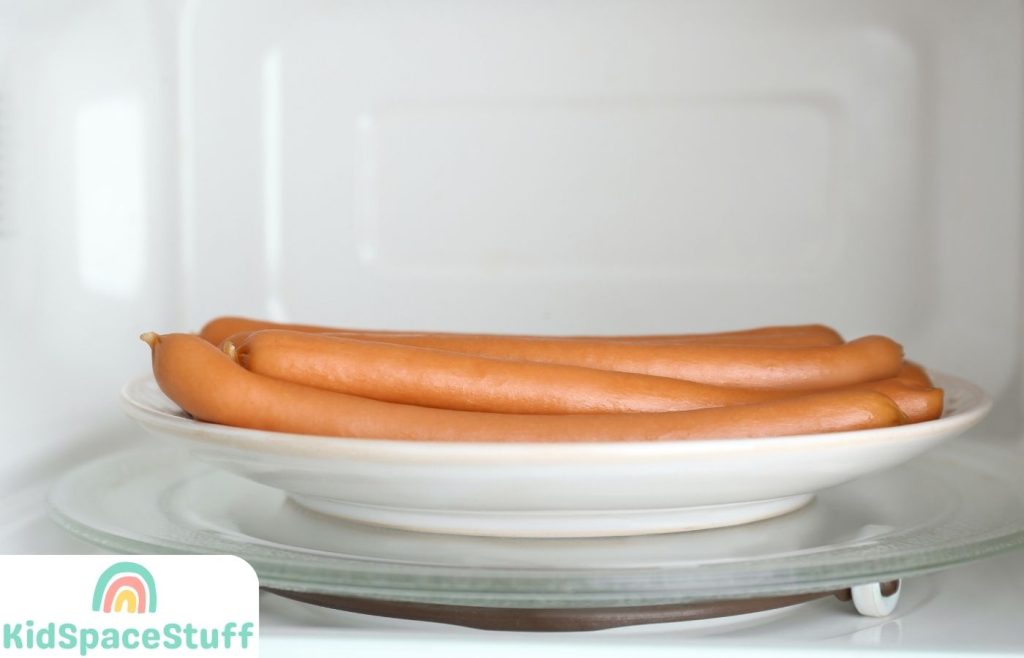 Tasty hotdogs on a plate in a microwave oven
